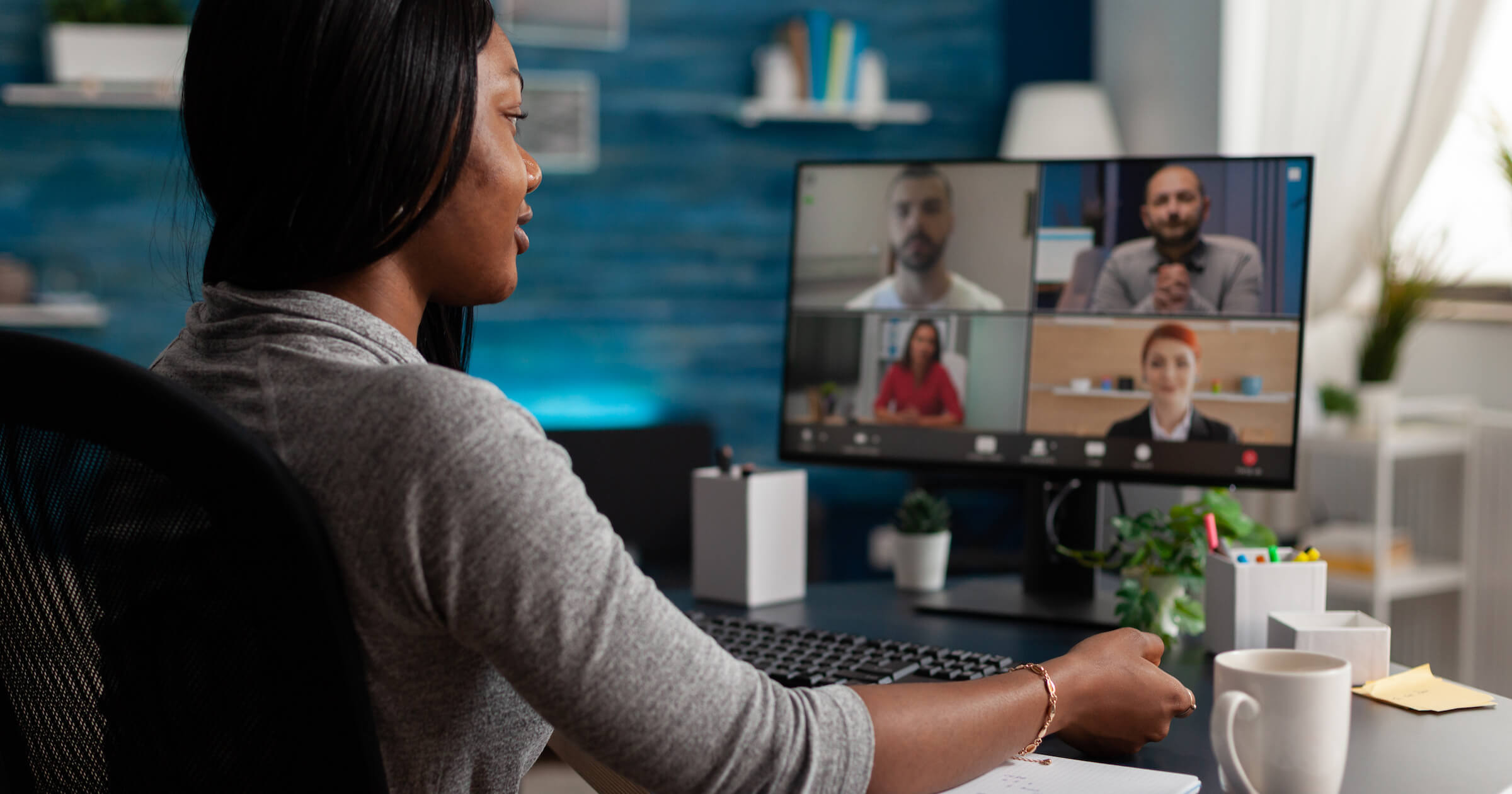 Woman working at home with video conference on the screen